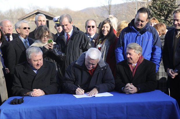AP photo by Nabil Mark - Gov. Tom Corbett, center, signs into law a bill that will provide $2.3 billion a year for improvements to Pennsylvania's highways, bridges and mass-transit systems.