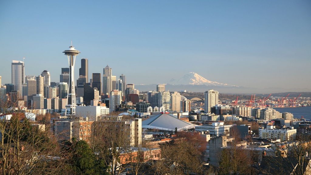 Mt. Rainier peaks over the Seattle skyline. Natural beauty, a bustling job market, and high quality life have this Pacific metro booming.