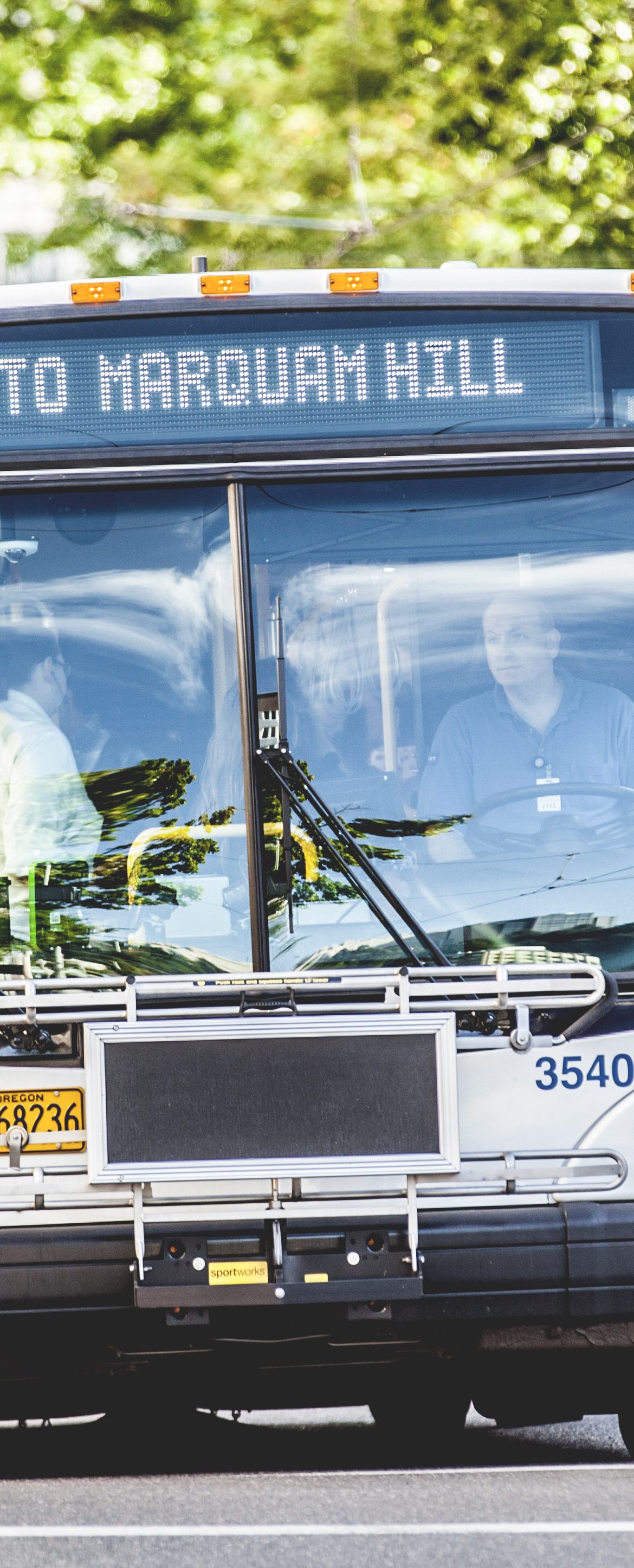 A passenger hops onto a bus on a sunny day