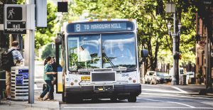 A passenger hops onto a bus on a sunny day