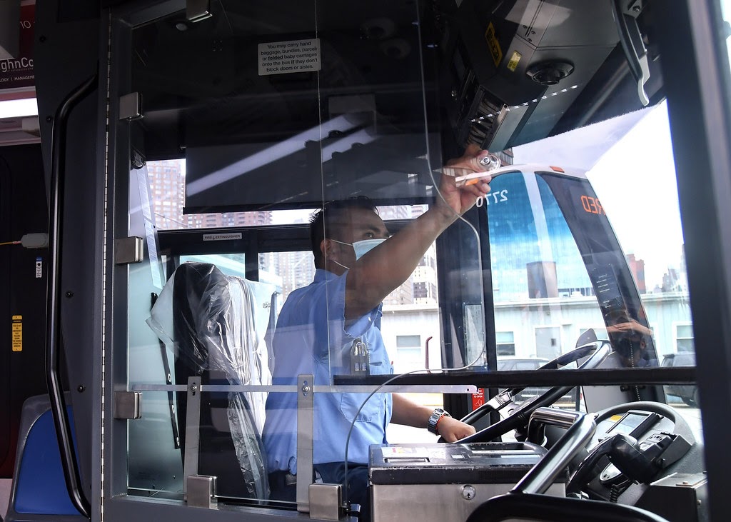 bus driver wearing mask adjusts mirror