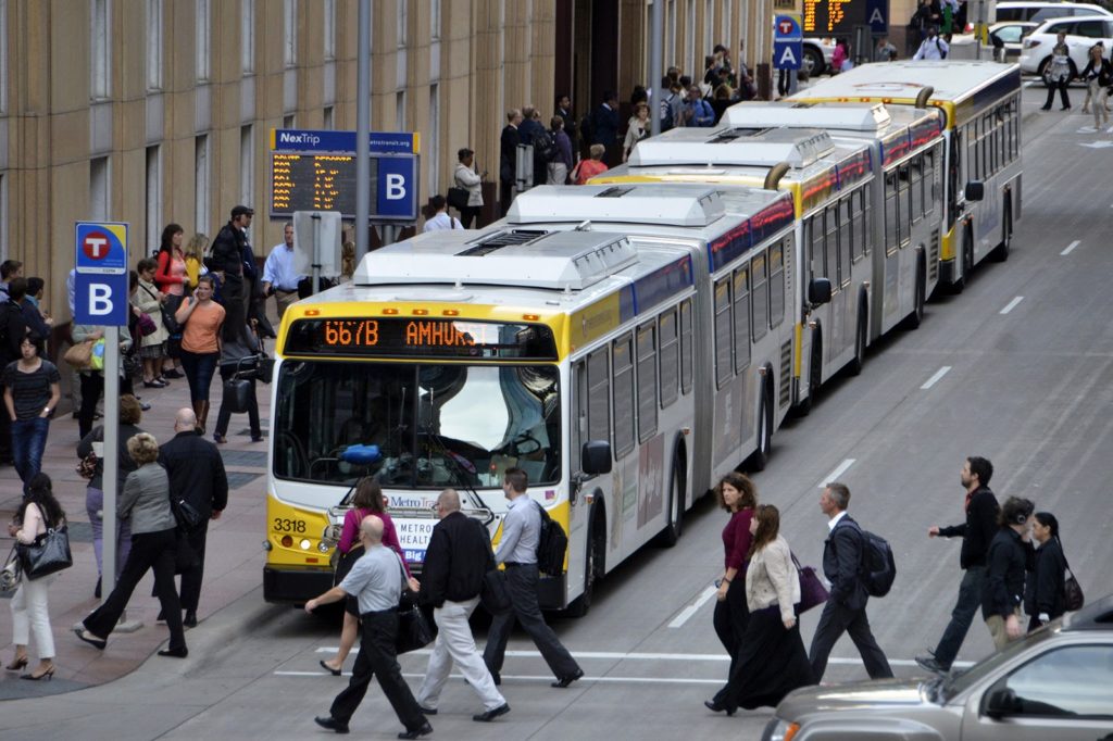 Bus stopping in front of a crosswalk filled with pedestrians