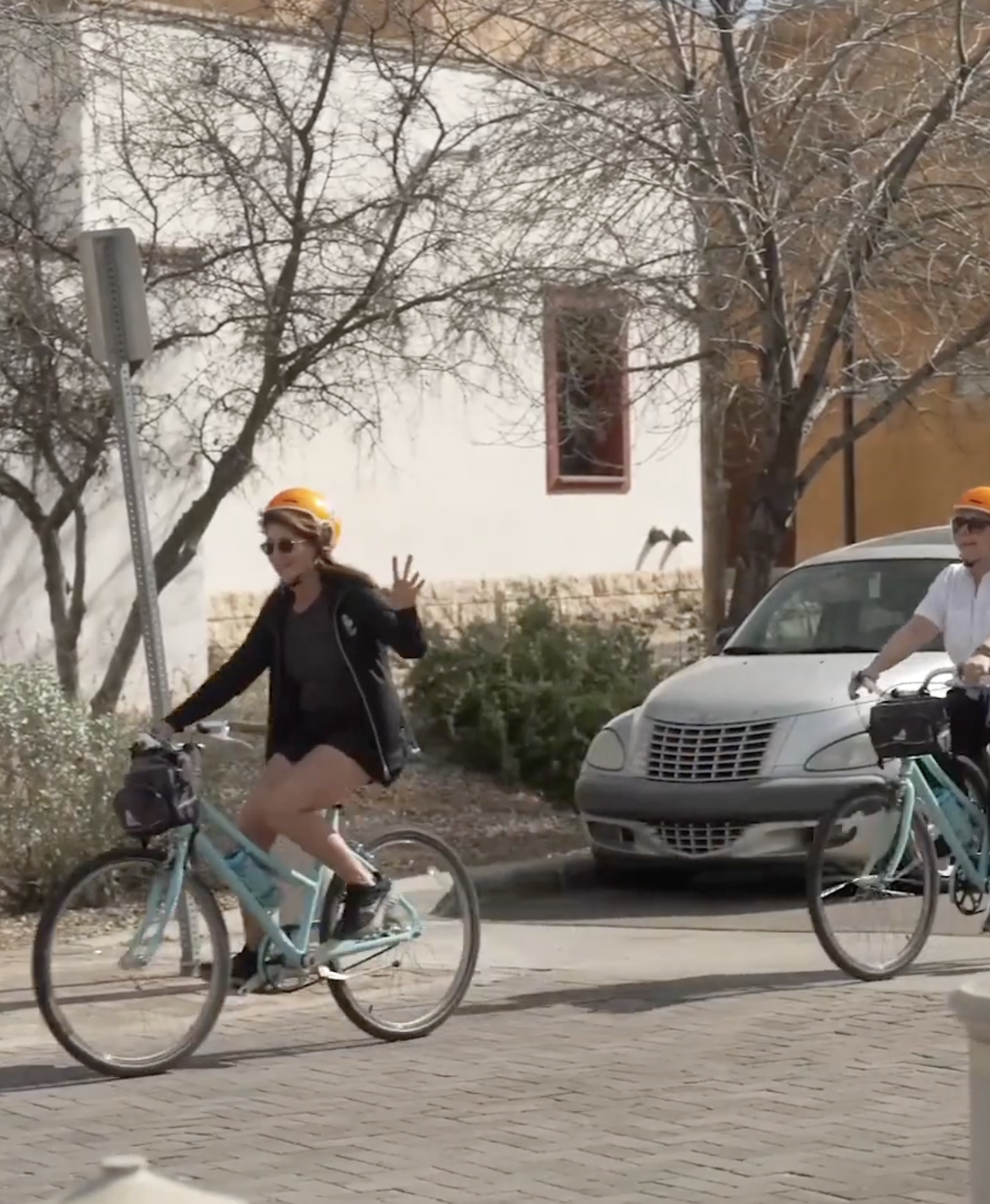 three cyclists ride their bikes down a tucson street