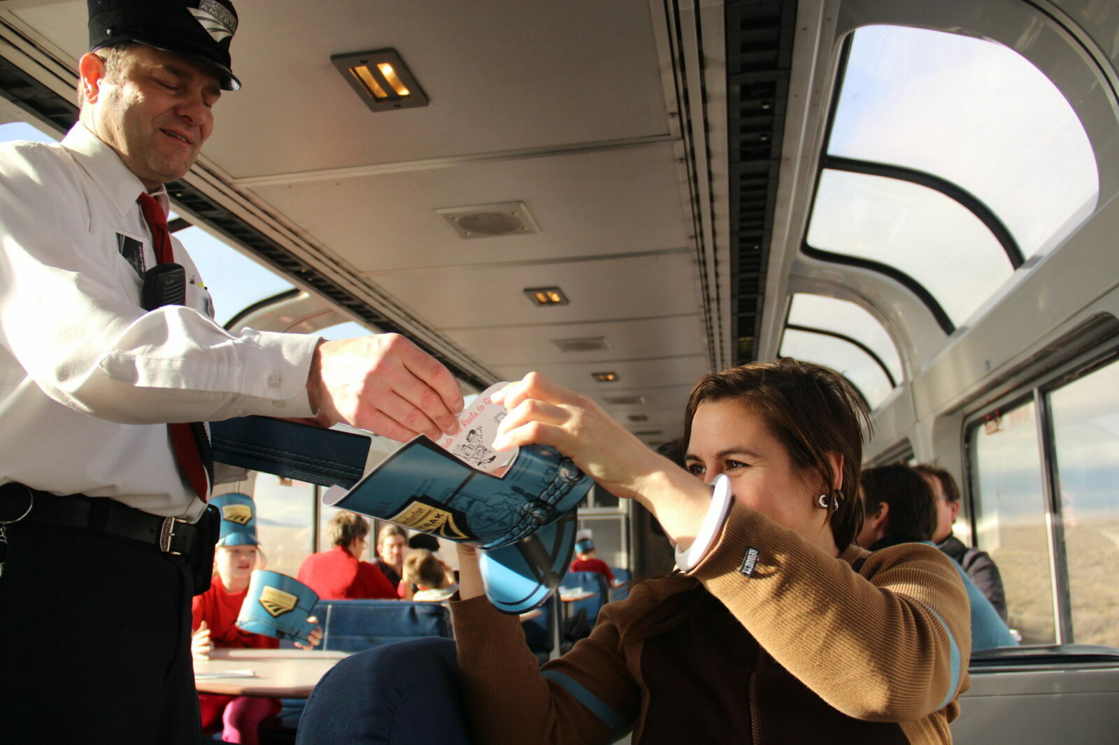 An Amtrak employee interacts with passengers on the train