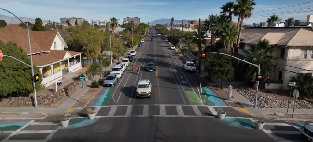 A Complete Street with a short crosswalk, two bike lanes, two lanes for cars, and wide sidewalks for pedestrians