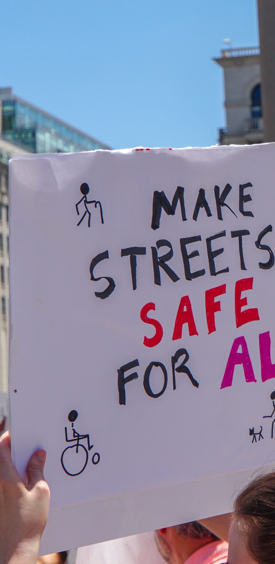 Advocate holding a sign that says "Make streets safe for all"