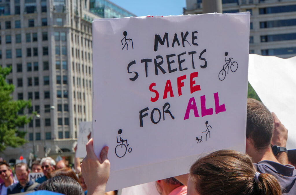 Advocate holding a sign that says "Make streets safe for all"