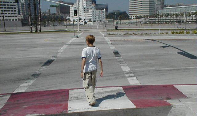 a child stands in front of a long crosswalk