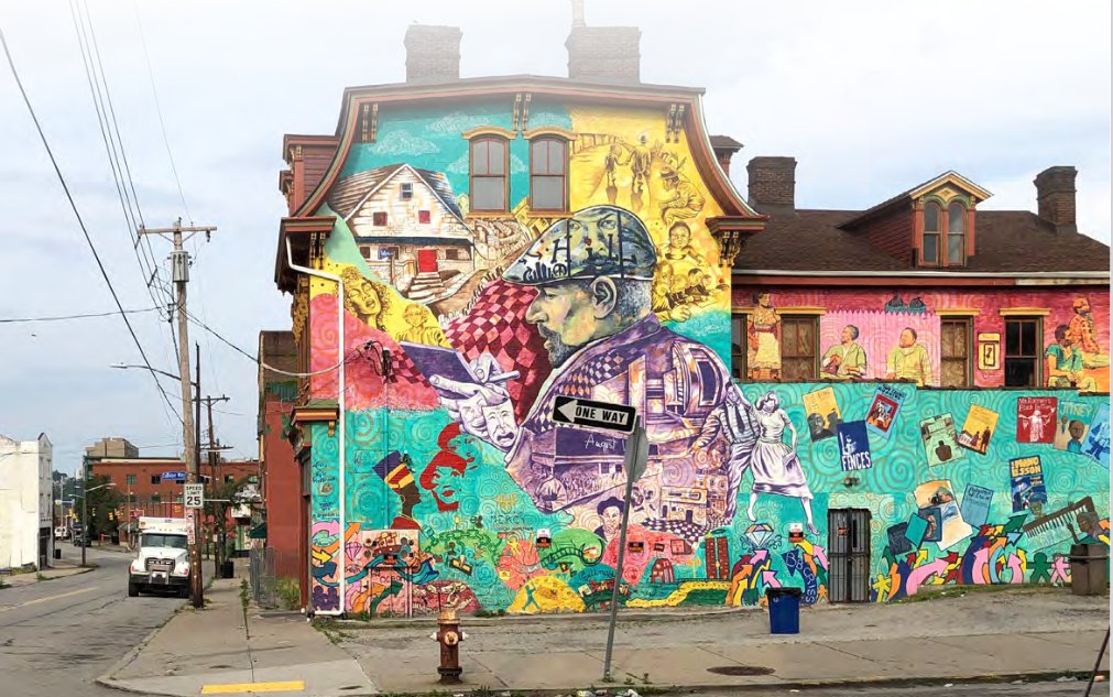 A brightly colored mural decorates the side of a building in the Hill District