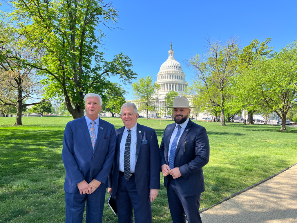 The three mayors smile broadly in front of the U.S. Capitol building in full suits (Monroe Mayor Friday Ellis sports a cowboy hat)