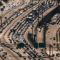 Highway lanes crisscross across an otherwise barren landscape. Rows of tightly clustered cars dot the lanes