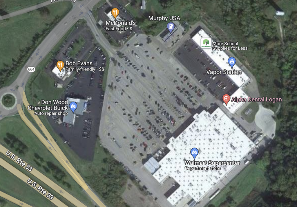 Google map satellite image of a large parking lot with a wallmart, fast food, and other businesses