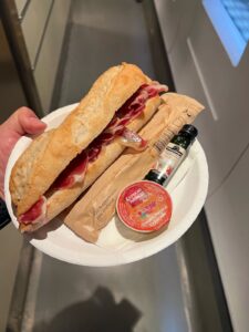 A large sandwich made of pieces of fresh ham and a baguette