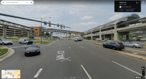 Google Maps screenshot of VA-123, showing the pedestrian bridge in the background connecting to the metro station on the right. A car enters the roadway through a slip lane. There are at least six lanes of traffic shown.
