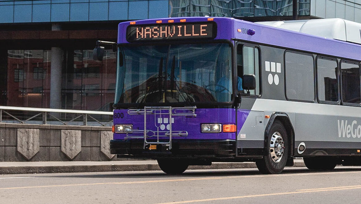 A purple WeGo Nashville bus travels down a city street